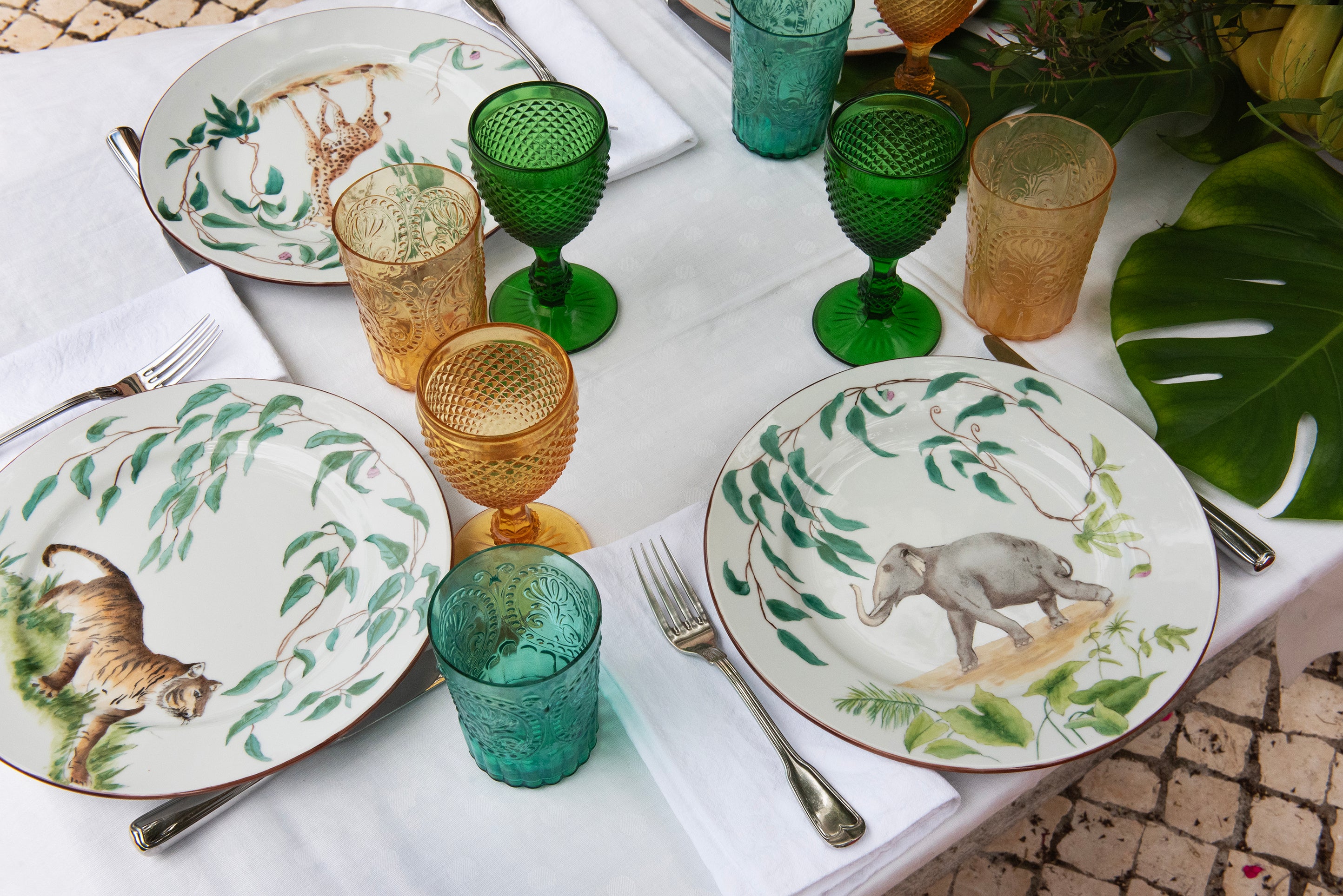 EVM Porcelain lifestyle mood image "Taste of Africa" entire plates, Giraffe, Elefant, Tiger close up on a table with plants