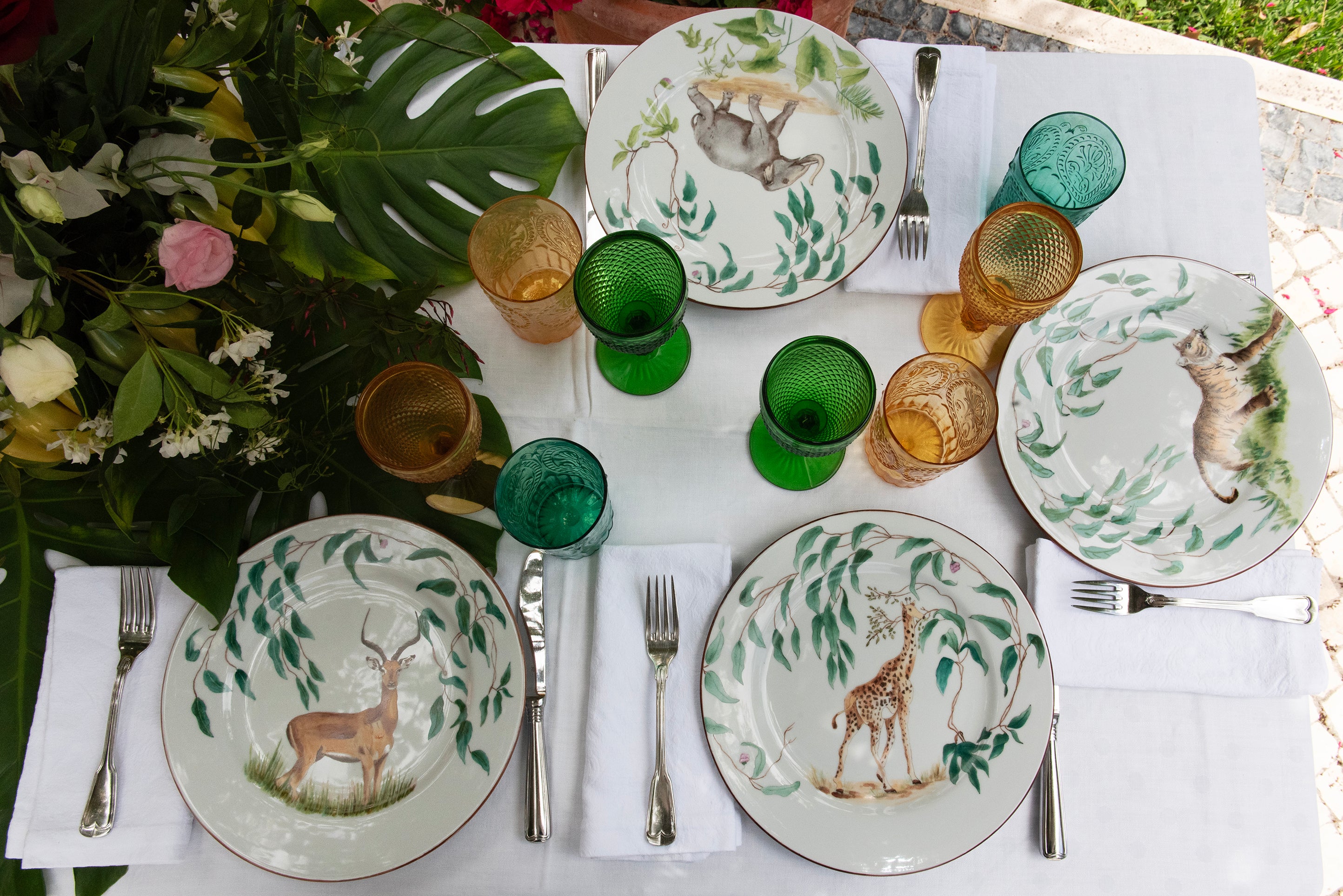 EVM Porcelain lifestyle mood image "Taste of Africa" entire plates showing an Elefant, Giraffe, Tiger, Antelope and Giraffe, set up on a table with decoration and cutlery